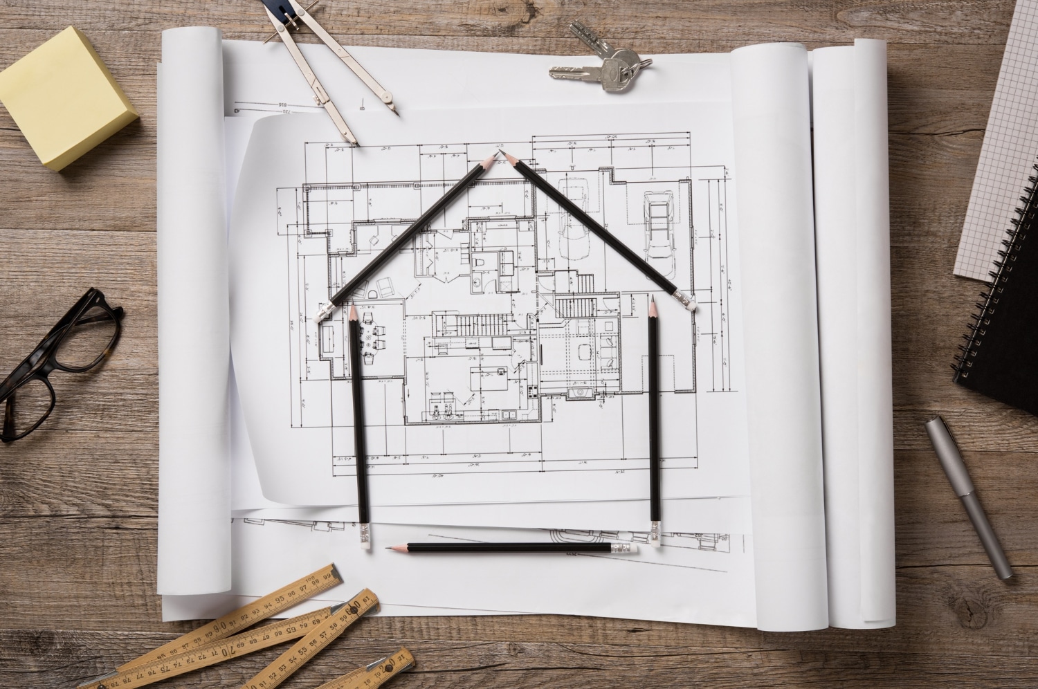 Vue de dessus des plans architecturaux, des rouleaux et des instruments de dessin sur la table de travail.